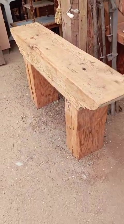 Una banca de tablón con la madera ya cepillada, dentro del taller